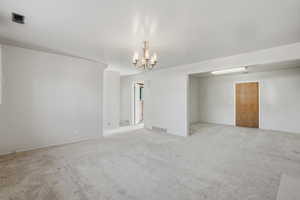 Family room featuring light colored carpet and hanging lights
