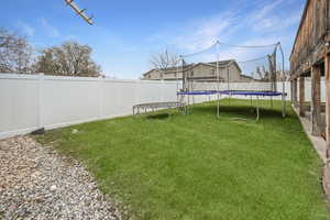 Fenced backyard with a trampoline
