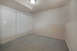 Unfurnished bedroom featuring carpet flooring and a closet