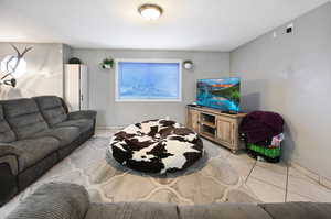 Living room featuring light tile patterned floors and baseboards