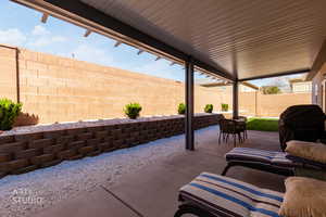 Fenced backyard featuring a patio and a grill