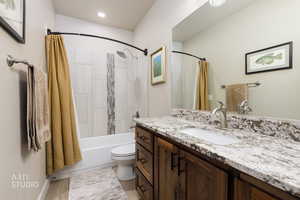 Bathroom with vanity, shower / tub combo, and light wood finished floors