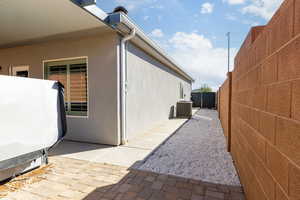 View of side of home featuring a fenced backyard and stucco siding