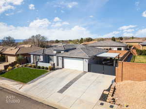 View of front facade with a garage, concrete driveway, a residential view, and stucco siding