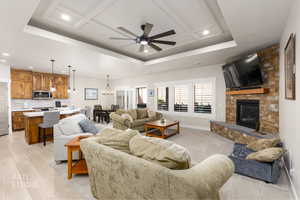 Living room featuring ceiling fan, recessed lighting, a large fireplace, and a raised ceiling