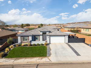 Prairie-style house featuring a residential view, a garage, stucco siding, and stone siding