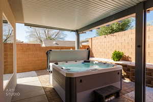 Fenced backyard with a patio area and a hot tub