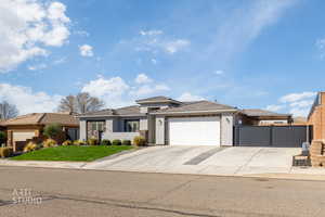 Prairie-style home featuring stucco siding, an attached garage, and concrete driveway