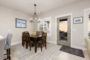 Dining area featuring light wood-type flooring and a chandelier