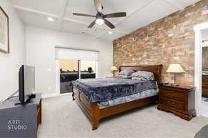 Bedroom featuring access to outside, light colored carpet, coffered ceiling, an accent wall, and ceiling fan
