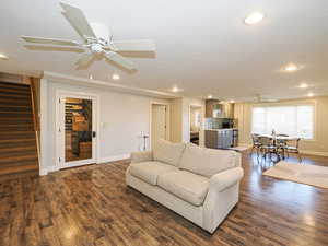 Living room with ceiling fan, dark wood finished floors, and recessed lighting