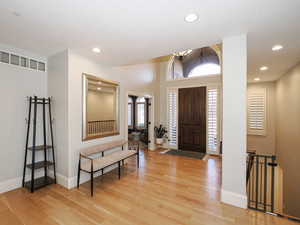 Entrance foyer with light wood-style flooring and recessed lighting