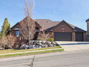View of front of house featuring brick siding, a garage, and concrete driveway