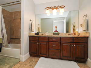 Full bathroom with double vanity and shower / tub combo with curtain