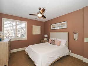 Bedroom featuring ceiling fan and dark colored carpet