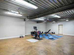 Exercise area featuring concrete flooring and baseboards