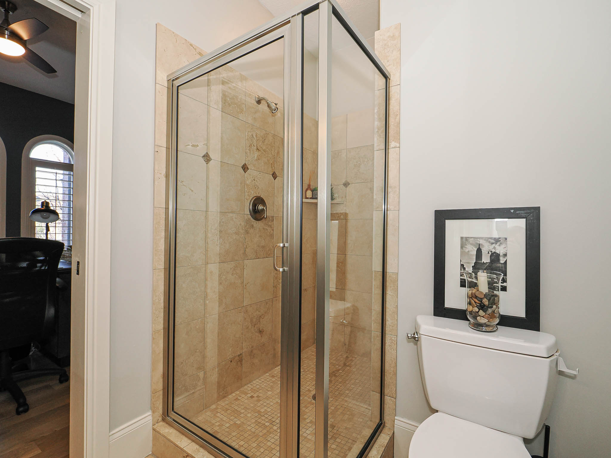 Full bath featuring a stall shower and a ceiling fan