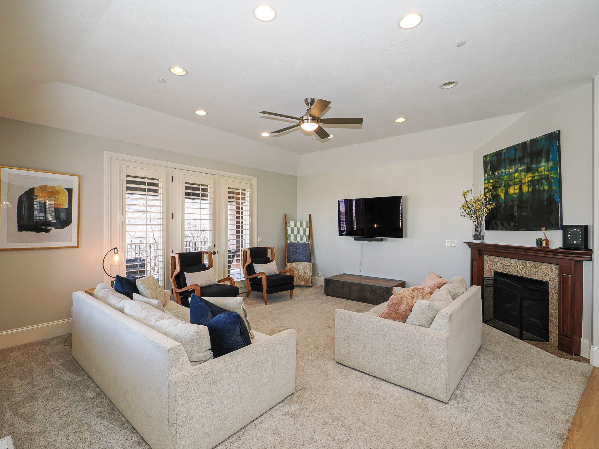 Living room featuring a ceiling fan, french doors, recessed lighting, a tiled fireplace, and carpet floors