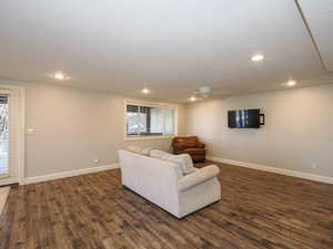 Living room with dark wood finished floors, a ceiling fan, and recessed lighting
