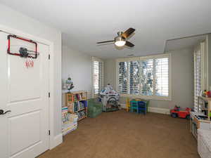 Playroom featuring ceiling fan and carpet flooring
