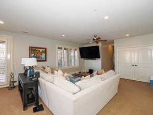 Living room featuring carpet floors, ceiling fan, and recessed lighting