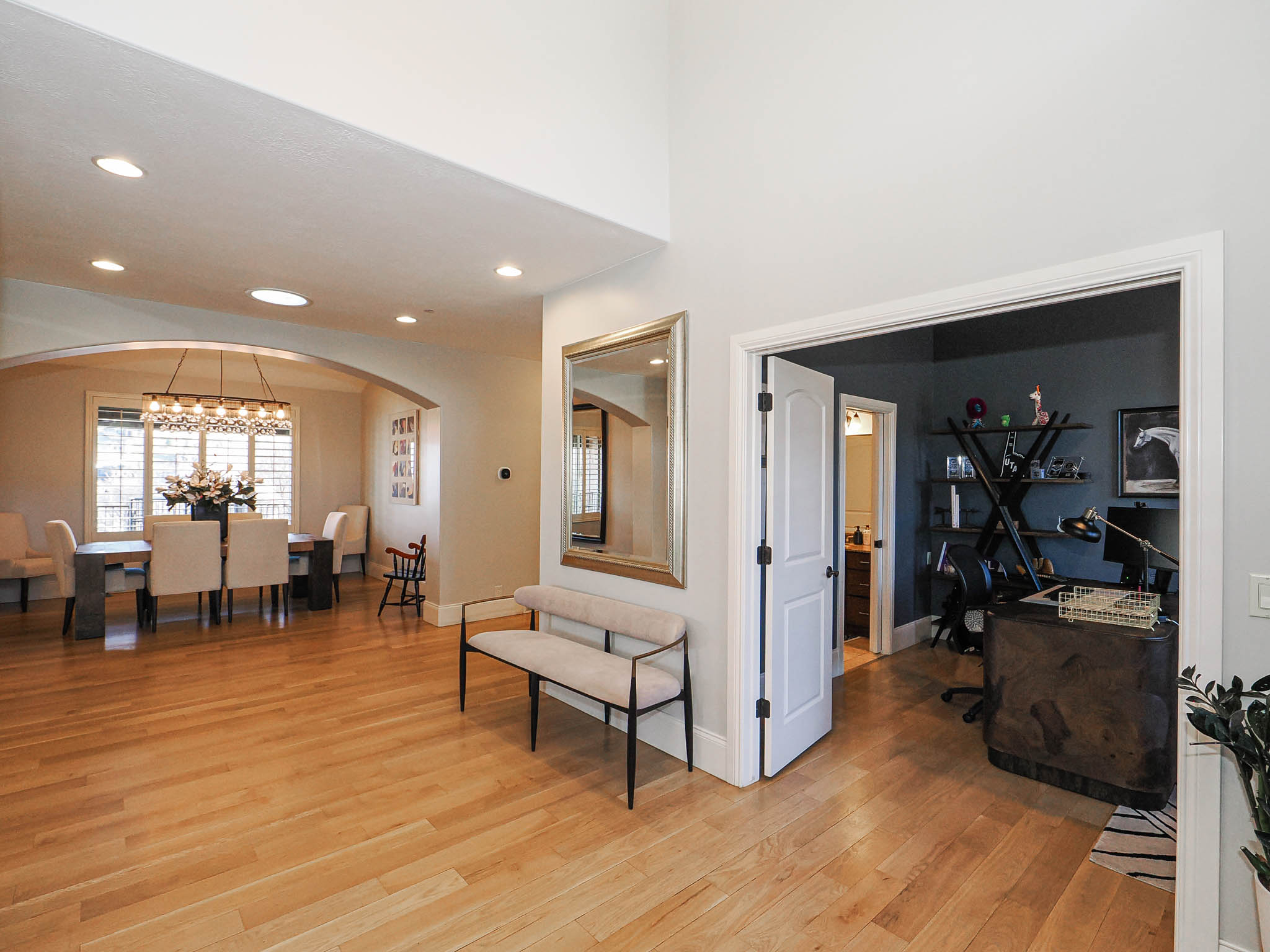 Entrance foyer with light wood-style floors, arched walkways, and a chandelier