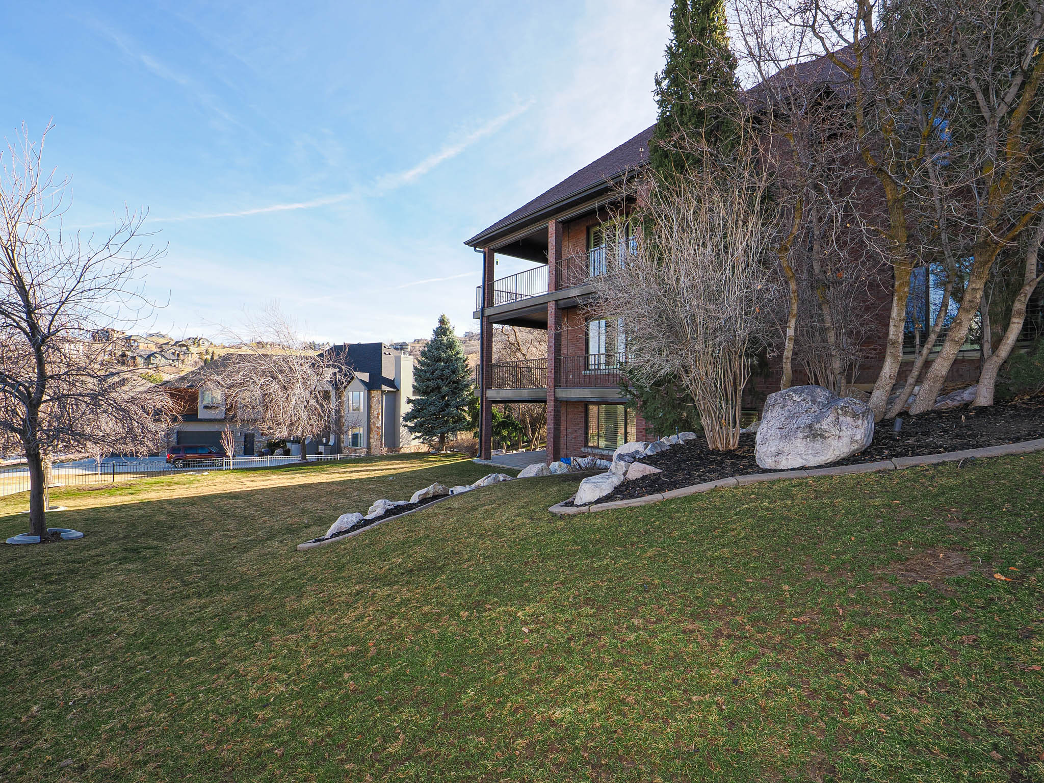View of grassy yard with a balcony
