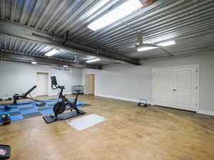 Workout area with finished concrete flooring and a garage