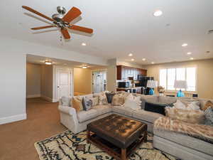 Living area with carpet floors, ceiling fan, and recessed lighting