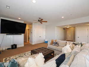 Living area with a ceiling fan, carpet flooring, and recessed lighting