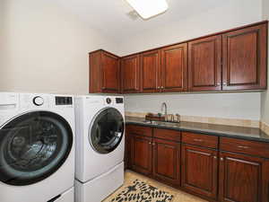 Laundry area with independent washer and dryer and cabinet space