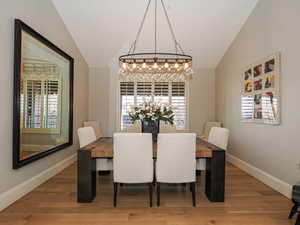 Dining area featuring wood finished floors and vaulted ceiling