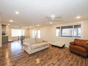 Living room with a ceiling fan, dark wood-type flooring, healthy amount of natural light, and recessed lighting