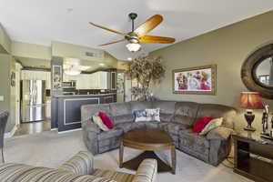 Living room featuring light carpet and ceiling fan