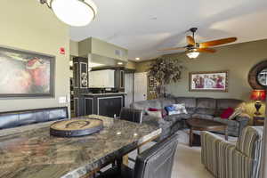 Dining room with light carpet, a ceiling fan, and recessed lighting