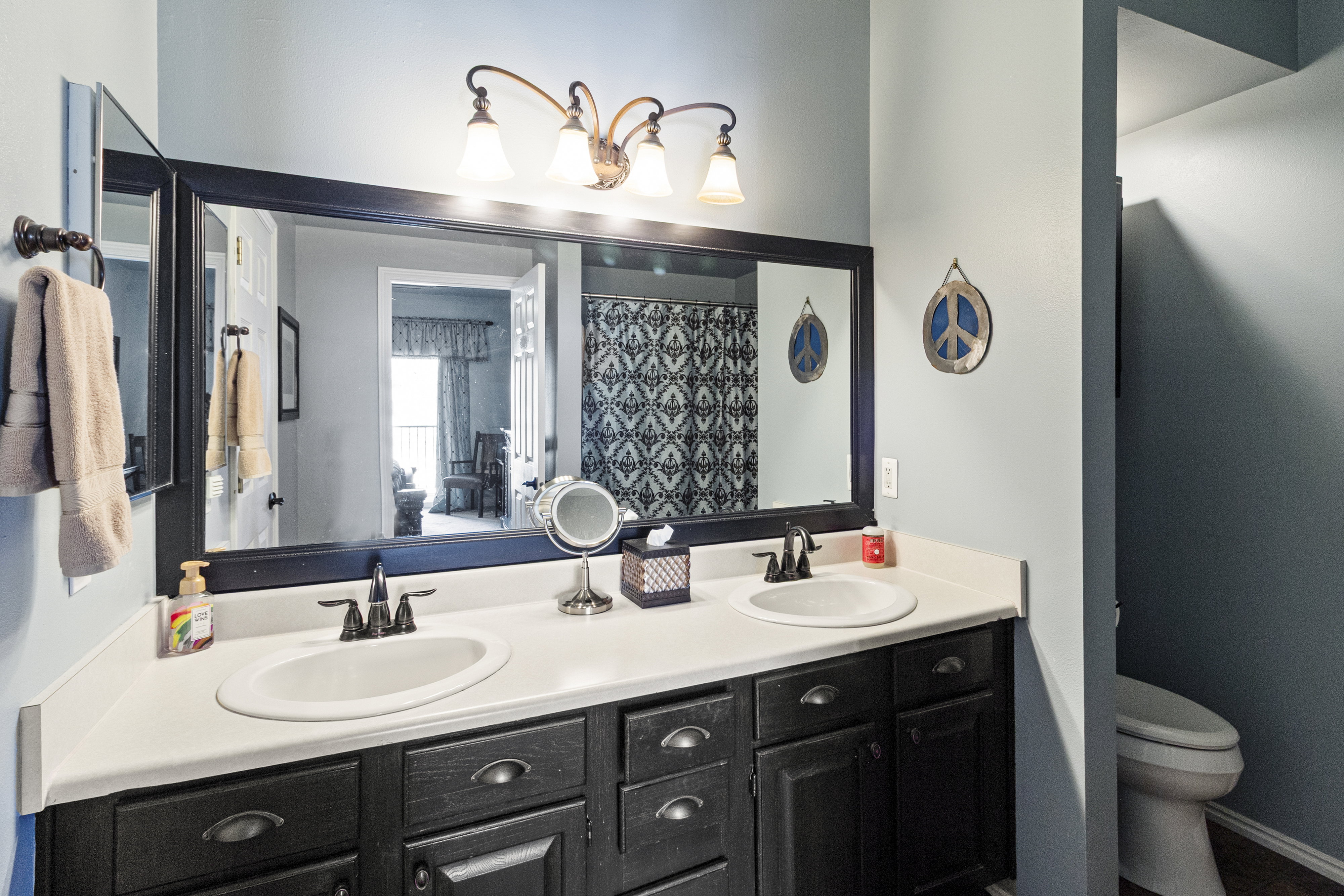 Full bath featuring double vanity and a shower with curtain