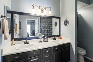 Full bath featuring double vanity and a shower with curtain