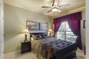 Carpeted bedroom with baseboards and a ceiling fan