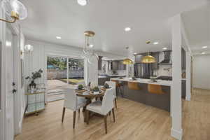 Dining area with light wood-type flooring and recessed lighting