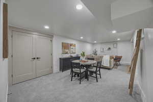 Dining room with light colored carpet and recessed lighting