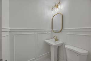 Bathroom featuring wainscoting and a decorative wall