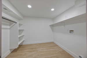 Laundry area with light wood finished floors, recessed lighting, and washer hookup