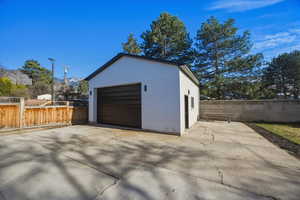 Detached garage featuring concrete driveway