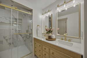 Ensuite Bathroom with double vanity and a marble finish shower
