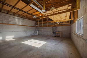 Garage featuring concrete block wall and a garage door opener