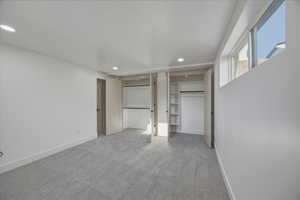 Unfurnished bedroom with light colored carpet, recessed lighting, and multiple closets