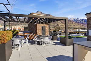View of patio / terrace with a mountain view, a pergola, and an outdoor kitchen / dining area
