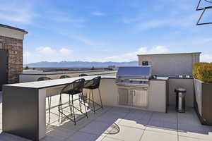 View of patio featuring a mountain view and an outdoor kitchen