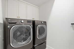 Laundry area featuring washer and dryer and cabinet space