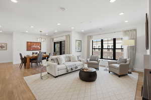 Living area with light wood-style floors and recessed lighting